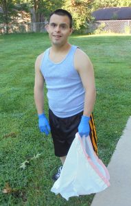 Daniel holding a trash bag while volunteering