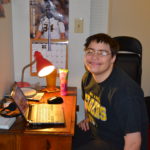 Ellen sitting at a desk in her bedroom