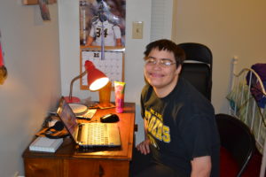 Ellen sitting at a desk in her bedroom