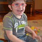 photo of Logan playing on the floor of his home