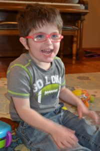 photo of Logan playing on the floor of his home