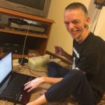 Doug sitting on the floor with his laptop
