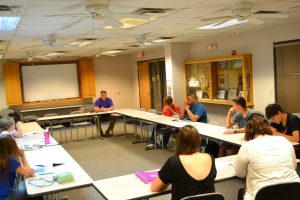 Classroom setting with several people focused on person speaking