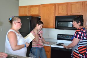 two women listen as a landlord explains how an apartment lease works