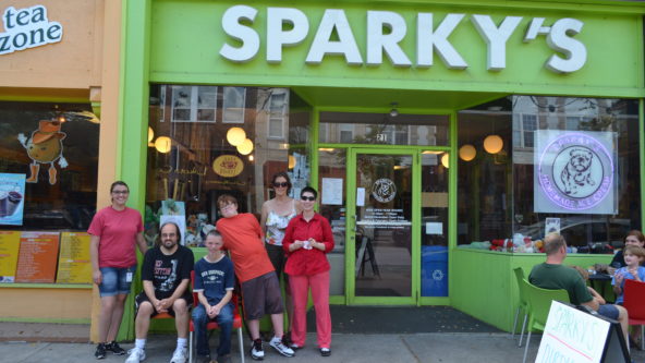 six people pose for a picture outside of sparky's ice cream shop