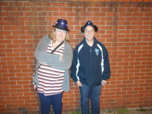 Two women pose with Michael Jackson hats.