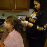 Photo of staff adding hair dye to a woman's hair.