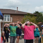 Group of people with eclipse glasses on looking at the sky.