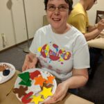 Woman holds several painted ornaments.