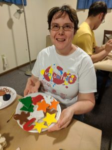 Woman holds several painted ornaments.