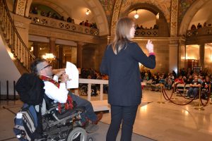 chris worth and an ASL interpreter on stage addressing the crowd at disability rights legislative day