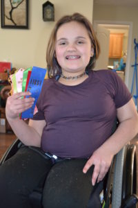 Sofia holds several ribbons while smiling