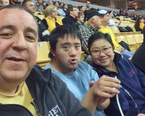 Rafael, Pablo and Yoke smile at the camera at a basketball game.