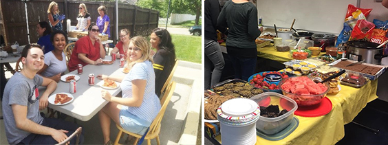 Staff sit around table eating and a large amount of home cooked food sits out buffet style.