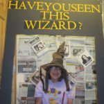 Woman wears wizard hat smiles for photo contest.