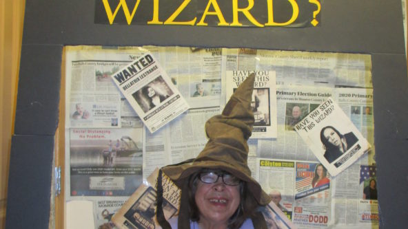 Woman wears wizard hat smiles for photo contest.