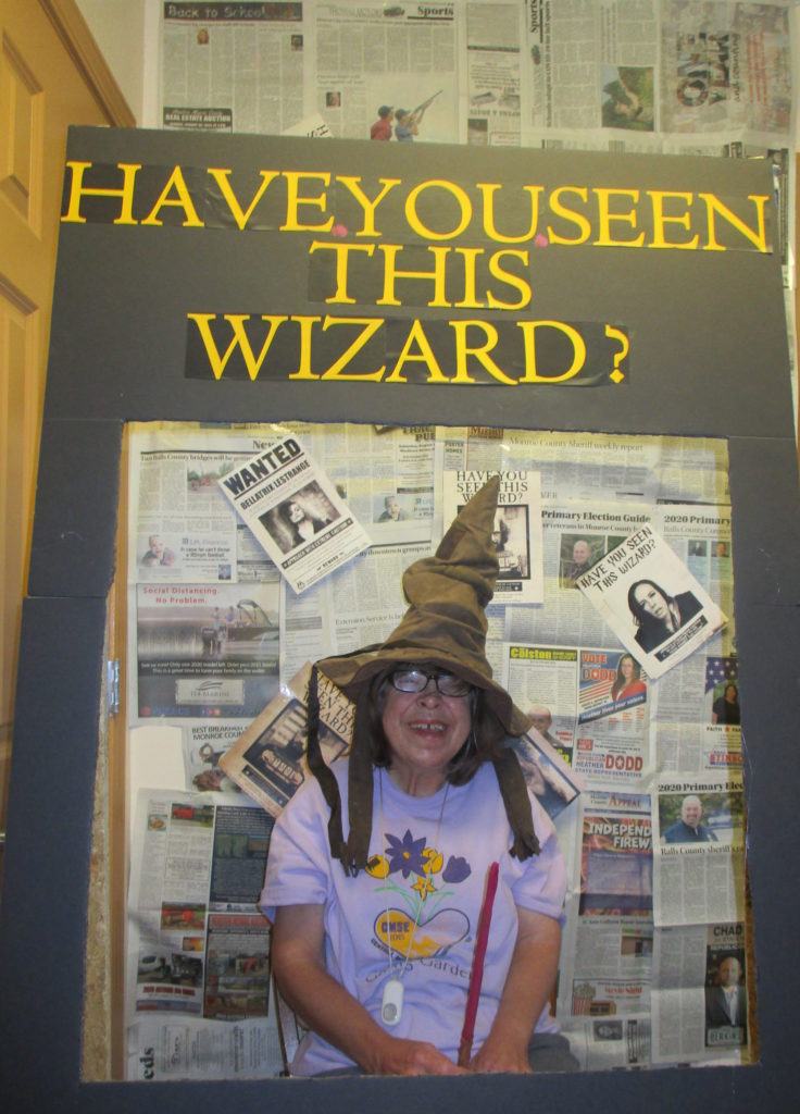 Woman wears wizard hat in a Harry Potter themed photo booth.
