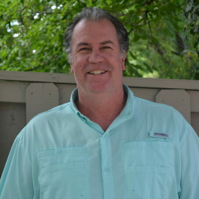 A tall caucasian man with sweeping grey hair.