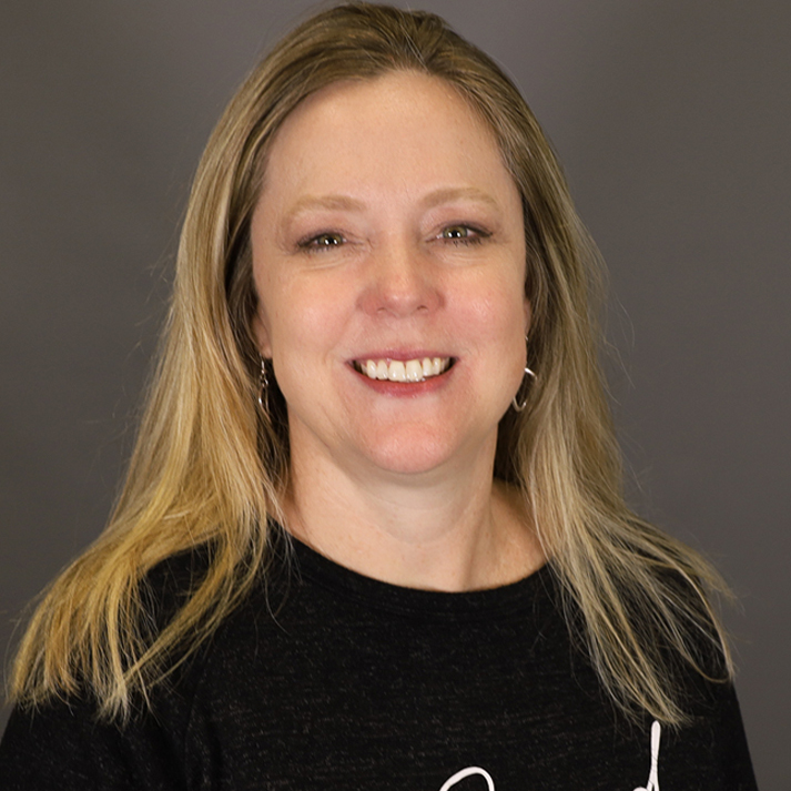 A Caucasian woman with shoulder length blonde hair wearing a black sweater.