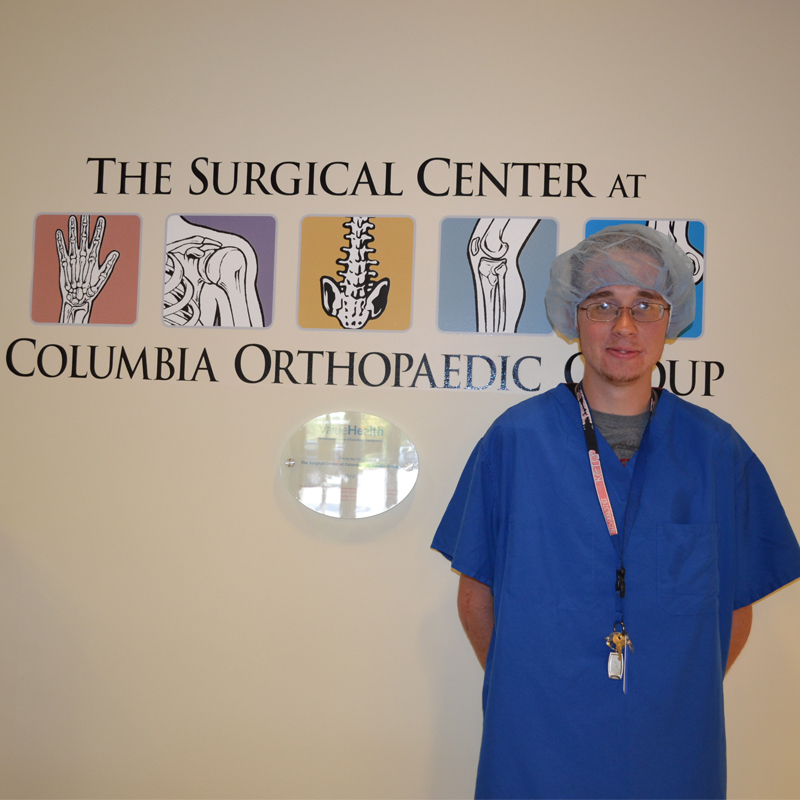 A young man wears scrubs at the Columbia Orthopedic Group.