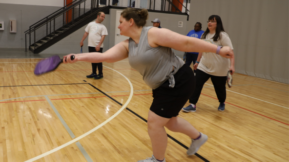 Dena swings a pickleball paddle inside the Columbia Fieldhouse at SOMO practice.