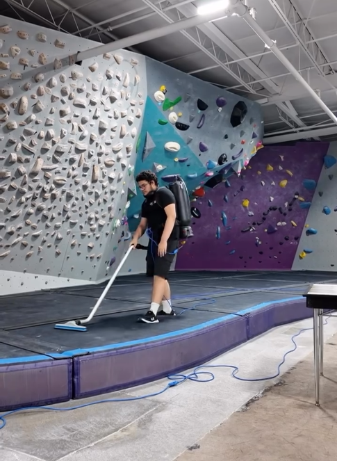 Cameron Using a vacuum while working.