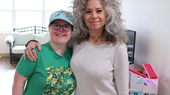Sydney and her mom, Lisa, pose for a photo in the living room which is filled with natural light.